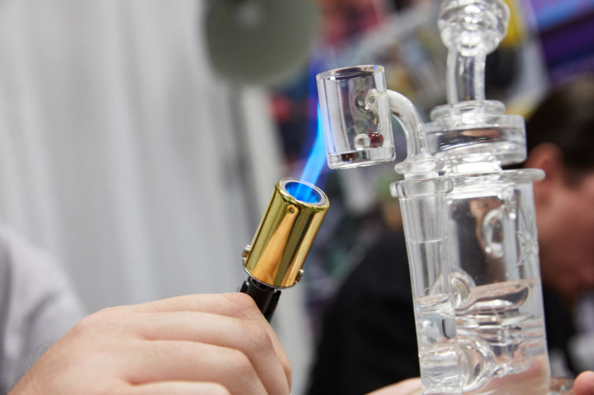 A torch heating the nail of a dab rig.