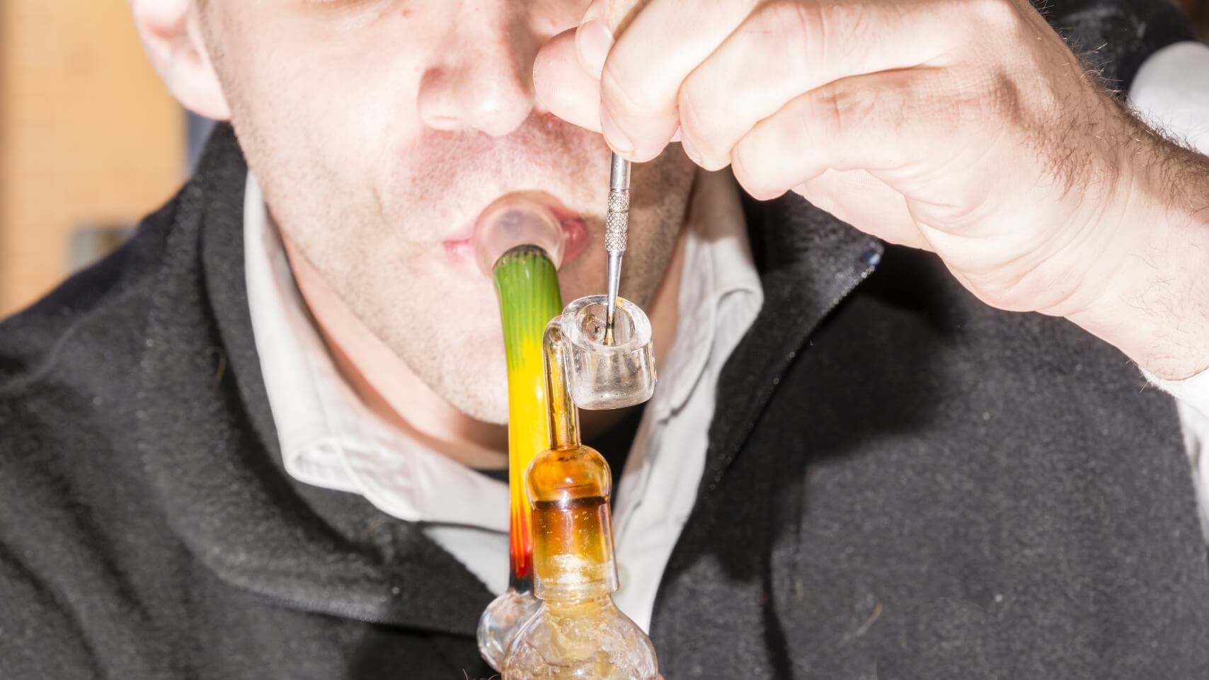 A person inhaling vapor from a dab rig.